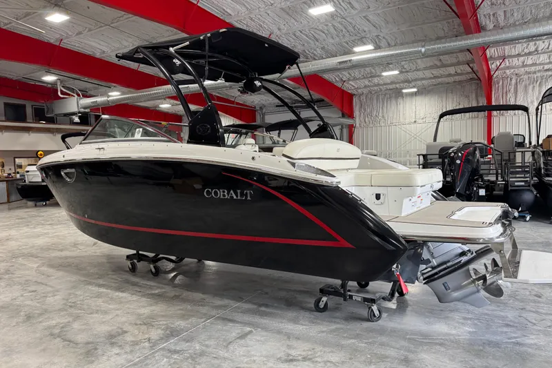 Slide: The Image of 2014 Cobalt R5 boat in showroom, black with red accents, on display. - 3