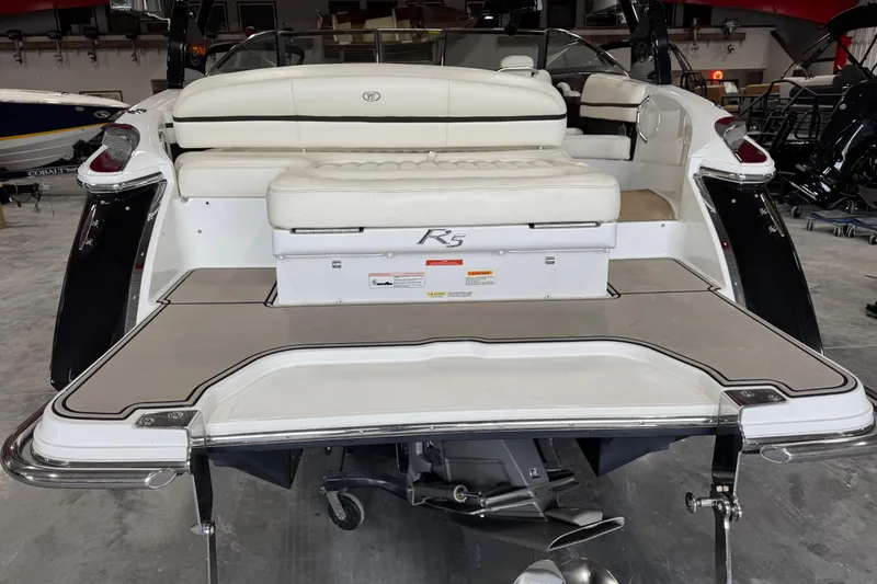 Slide: The Image of 2014 Cobalt R5 boat with white seating and swim platform in a showroom. - 5