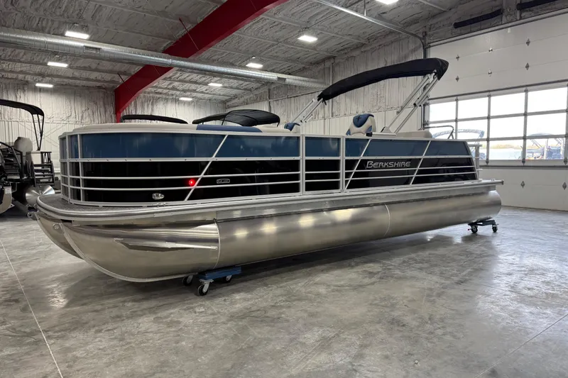 The Image of 2026 Berkshire 24 UL RE pontoon boat in a spacious indoor showroom. - 1