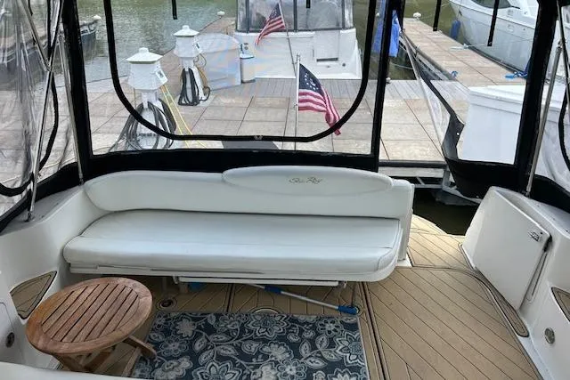 Slide: The Image of 2009 Meridian 391 Sedan yacht interior with white seating, wooden table, and dock view. - 14
