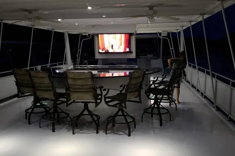 Slide: The Image of Luxurious 2012 Thoroughbred Houseboat 21x103 with outdoor seating and TV on deck at night. - 15