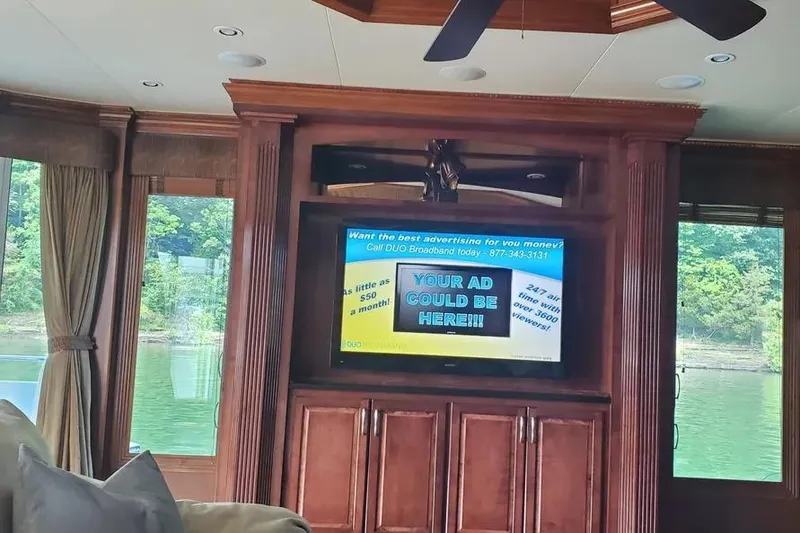 Slide: The Image of Luxurious 2012 Thoroughbred Houseboat interior with TV and scenic lake view. - 7