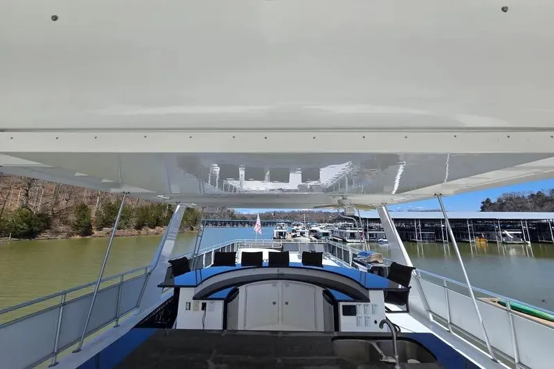 Slide: The Image of 2012 Thoroughbred Houseboat 21x103 on a serene lake with marina view. - 9