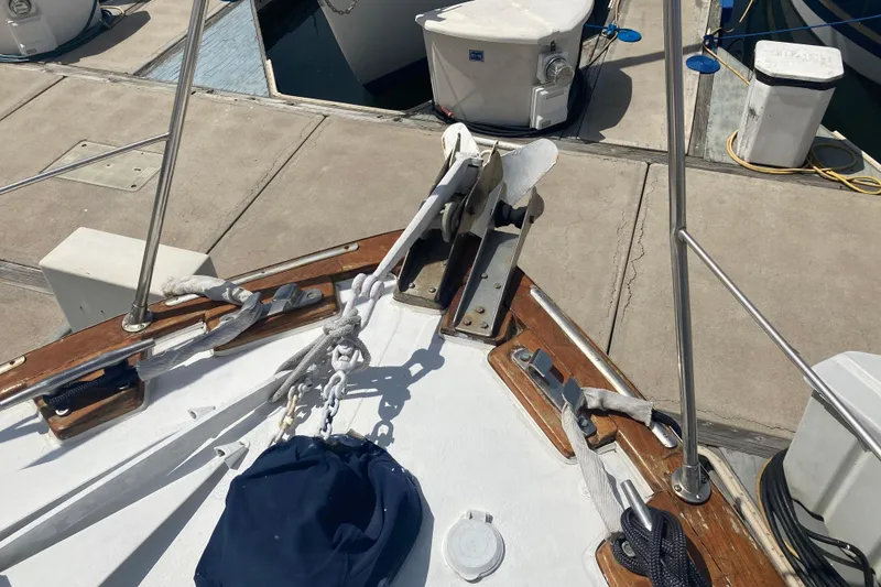 Slide: The Image of Bow of 1986 Island Gypsy 40 Motor Yacht docked, featuring anchor and mooring lines. - 10