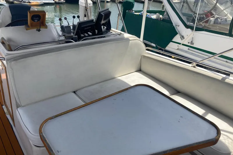 Slide: The Image of 1986 Island Gypsy 40 Motor Yacht interior with white seating and navigation equipment. - 13