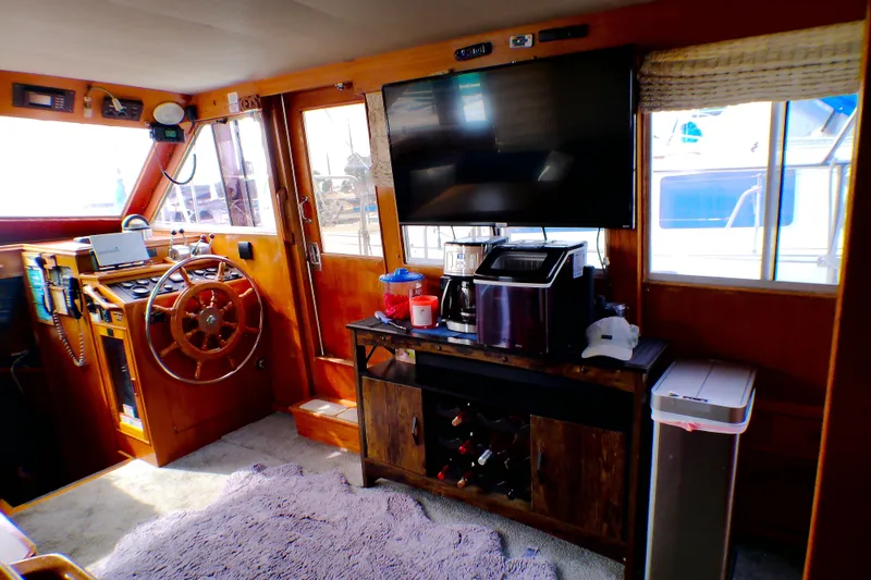 Slide: The Image of Interior of 1986 Island Gypsy 40 Motor Yacht with helm, TV, and appliances. - 19
