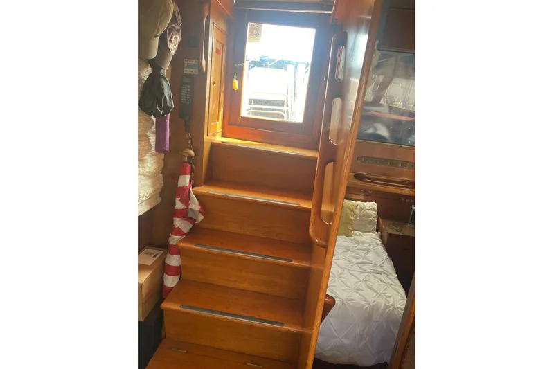 Slide: The Image of Interior of 1986 Island Gypsy 40 Motor Yacht with wooden stairs and cozy cabin. - 26