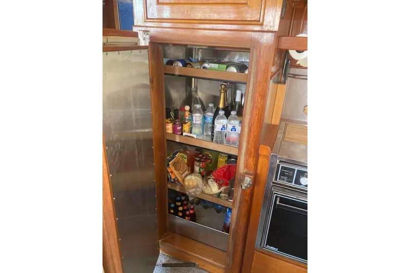 Slide: The Image of Pantry inside 1986 Island Gypsy 40 Motor Yacht, stocked with beverages and food items. - 30