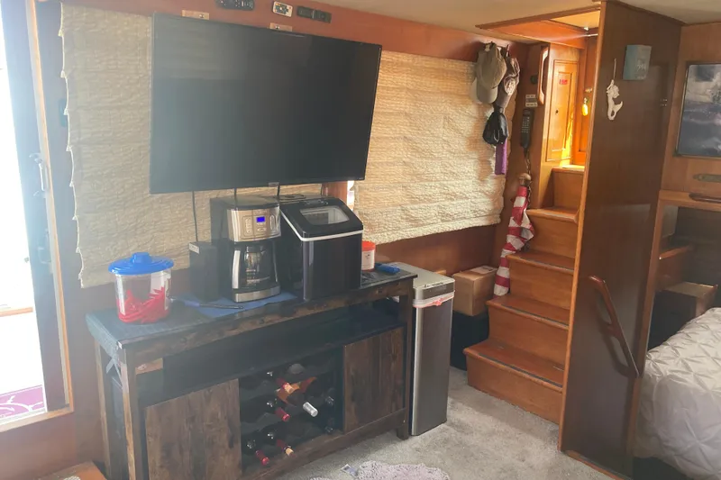 Slide: The Image of Interior of 1986 Island Gypsy 40 Motor Yacht with TV, coffee maker, and stairs. - 32