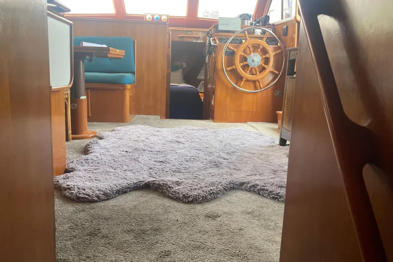Slide: The Image of Interior of 1986 Island Gypsy 40 Motor Yacht with wooden helm and plush rug. - 34