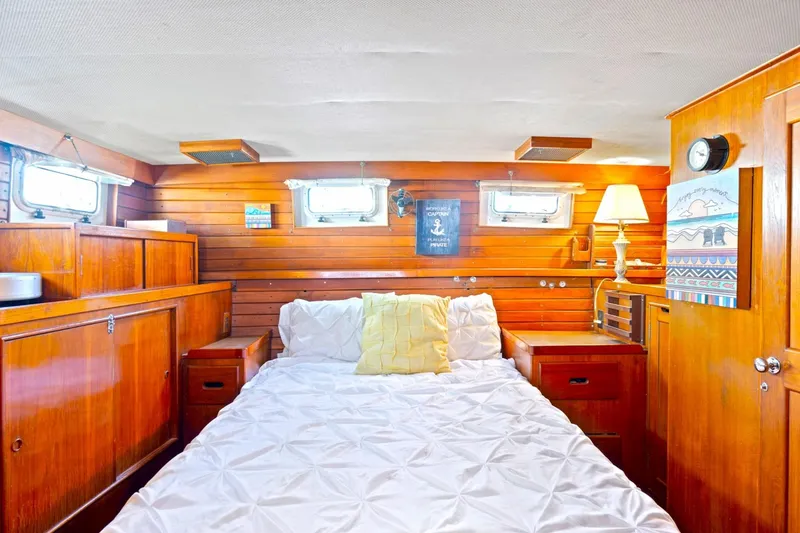 Slide: The Image of Cozy cabin interior of 1986 Island Gypsy 40 Motor Yacht with wooden paneling and bed. - 35