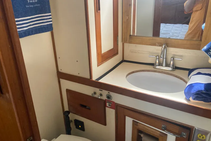 Slide: The Image of 1986 Island Gypsy 40 Motor Yacht bathroom with sink, mirror, and nautical decor. - 39