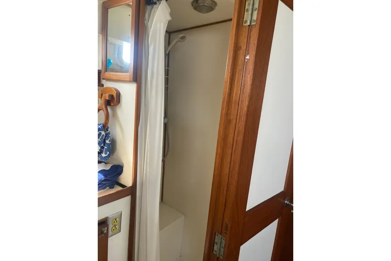 Slide: The Image of Shower area inside 1986 Island Gypsy 40 Motor Yacht with wooden door and mirror. - 40