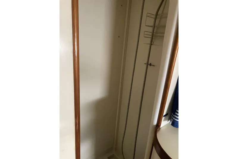 Slide: The Image of Shower area inside 1986 Island Gypsy 40 Motor Yacht, featuring wooden trim and storage racks. - 44