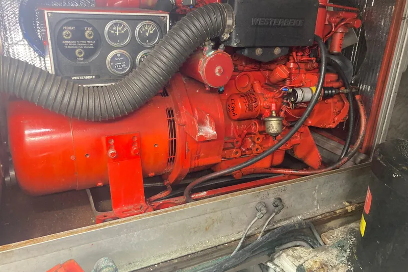 Slide: The Image of Engine compartment of a 1986 Island Gypsy 40 Motor Yacht with a red Westerbeke generator. - 49