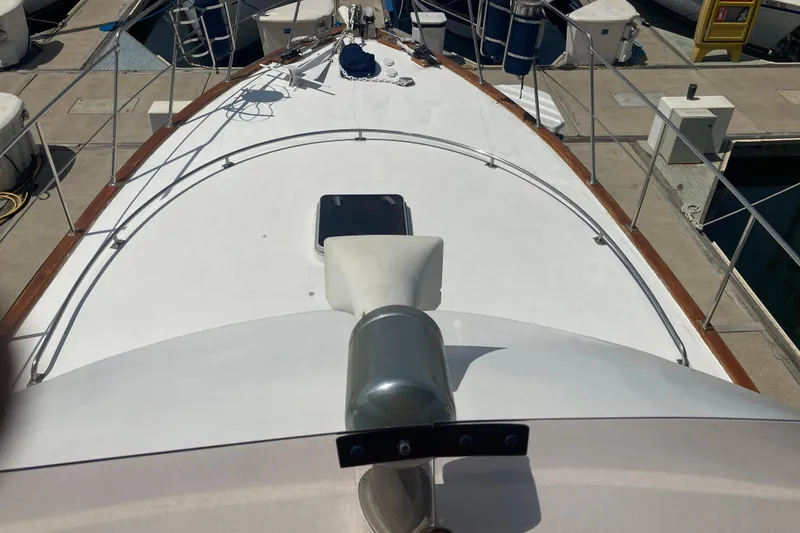 Slide: The Image of 1986 Island Gypsy 40 Motor Yacht deck view at marina, showcasing sleek design and mooring setup. - 6