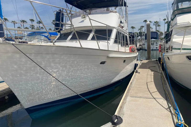 Slide: The Image of 1986 Island Gypsy 40 Motor Yacht docked at marina under clear sky. - 8