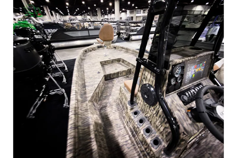 Slide: The Image of 2026 Excel 220 Bay Pro Elite boat interior with advanced dashboard and seating at a boat show. - 11