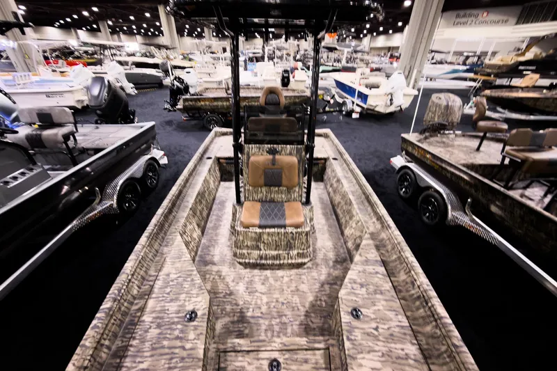 Slide: The Image of 2026 Excel 220 Bay Pro Elite boat displayed at an indoor boat show. - 13