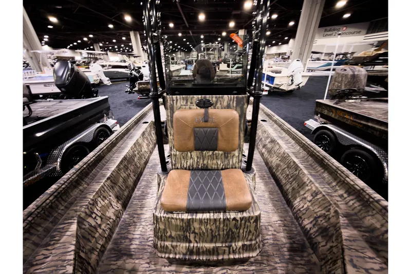Slide: The Image of 2026 Excel 220 Bay Pro Elite boat with camo interior at a boat show. - 14