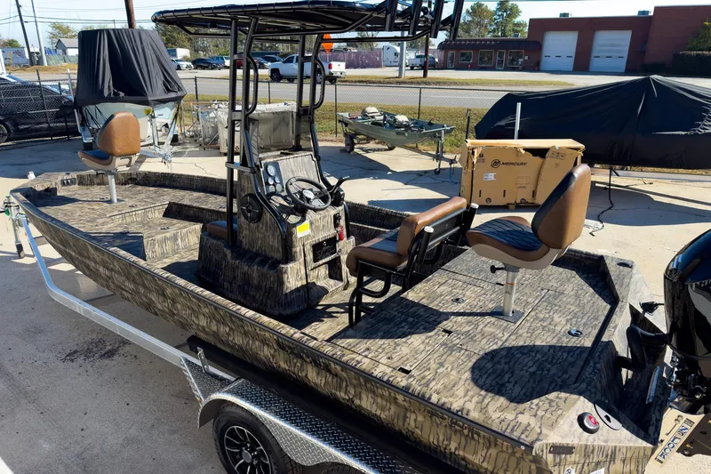 Slide: The Image of 2026 Excel Bay Pro Elite 220 boat with camo design, parked on a trailer in a lot. - 28