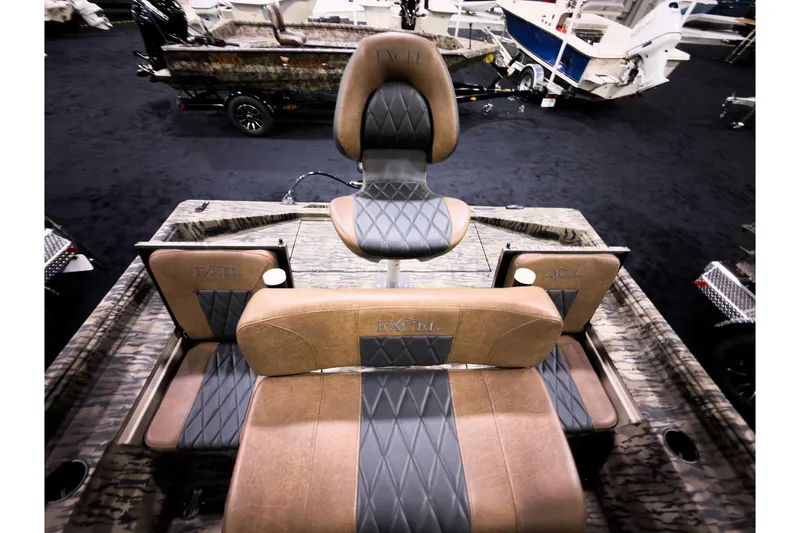 Slide: The Image of 2026 Excel 220 Bay Pro Elite boat interior with cushioned seating and camo design. - 8