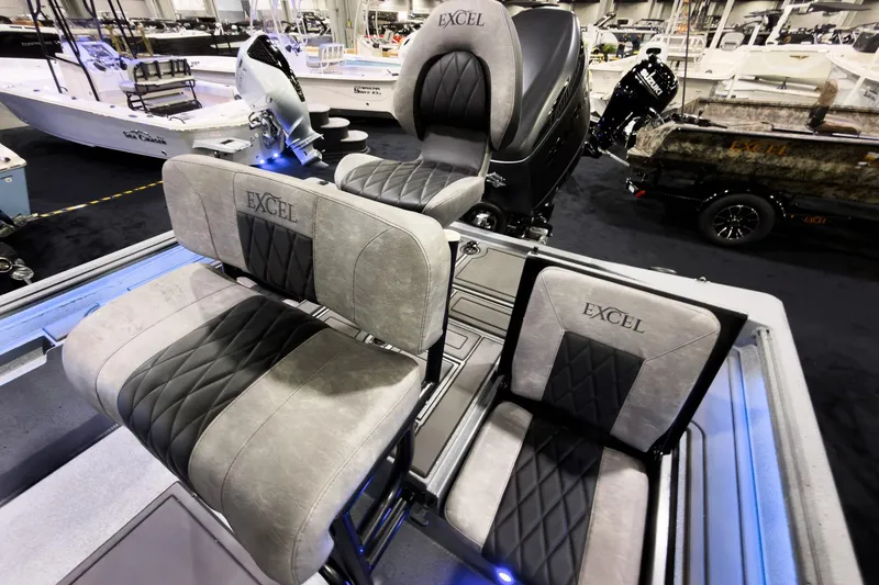 Slide: The Image of 2026 Excel 230 Bay Pro Elite boat seats with elegant design and branding at a boat show. - 9