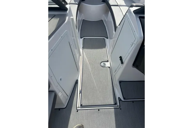 Slide: The Image of 2024 Yamaha Boats AR220 interior walkway with sleek design and storage compartments. - 10