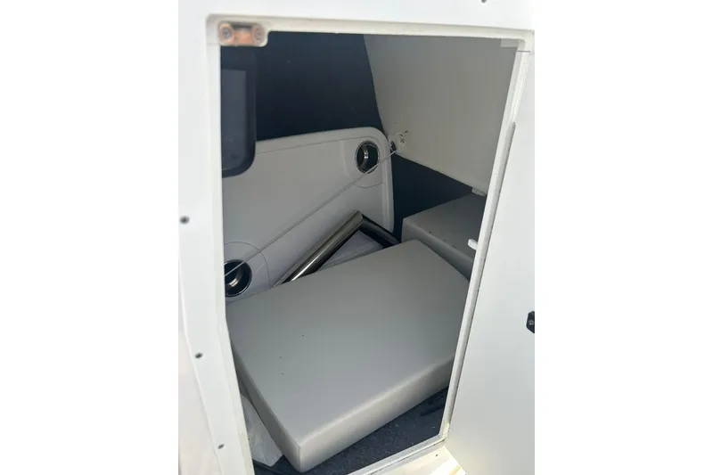 Slide: The Image of 2024 Yamaha Boats AR220 interior storage compartment with cushioned seating. - 9