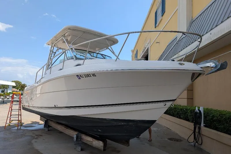 The Image of 2014 Robalo R305 Walkaround boat on dry dock, side view. - 0