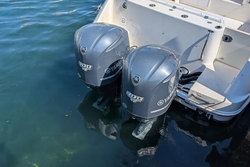 Slide: The Image of Twin Yamaha 300 engines on a 2014 Robalo R305 Walkaround boat in water. - 11