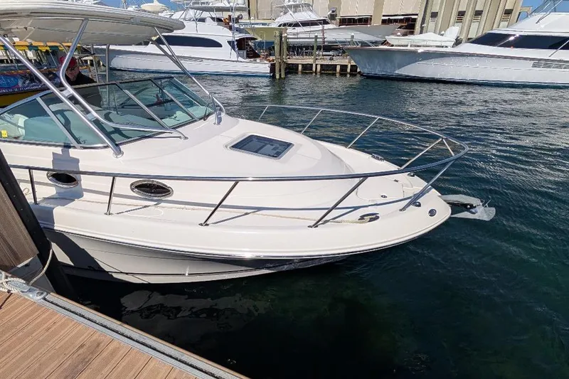 Slide: The Image of 2014 Robalo R305 Walkaround boat docked in marina, surrounded by other vessels. - 15