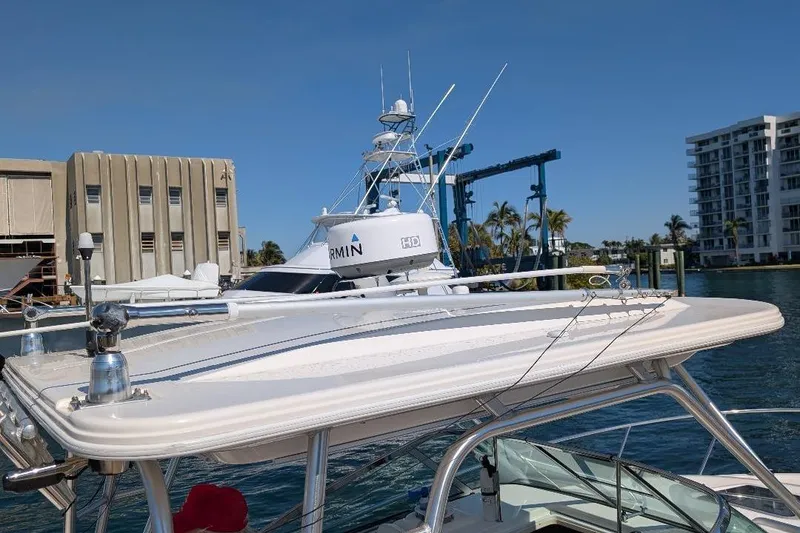 Slide: The Image of 2014 Robalo R305 Walkaround boat docked near waterfront buildings and palm trees. - 17