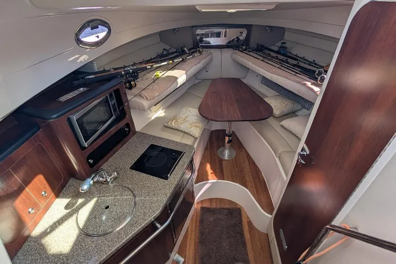 Slide: The Image of 2014 Robalo R305 Walkaround cabin interior with kitchenette and seating area. - 25