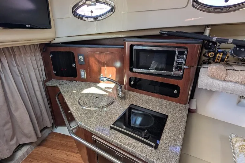 Slide: The Image of 2014 Robalo R305 Walkaround cabin with kitchenette, featuring microwave and stove. - 30