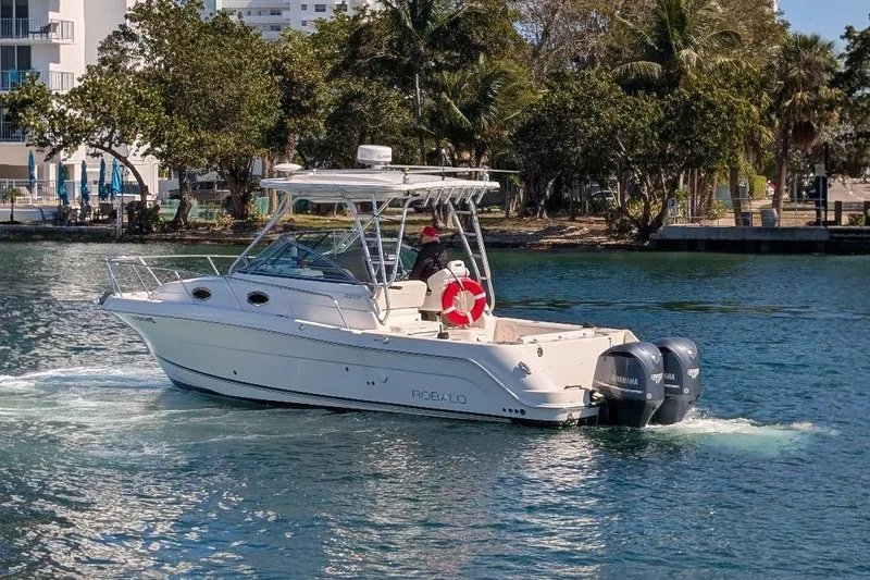 Slide: The Image of 2014 Robalo R305 Walkaround boat cruising on a sunny waterway. - 5