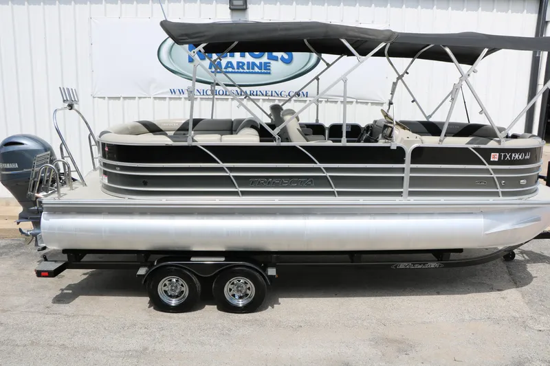 Slide: The Image of 2020 Trifecta 24RF LE pontoon boat with canopy on trailer, parked outdoors. - 12