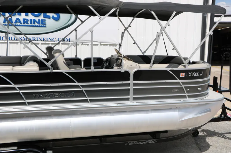 Slide: The Image of 2020 Trifecta 24RF LE pontoon boat with canopy, docked at a marina. - 14