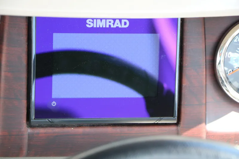 Slide: The Image of Simrad display on 2020 Trifecta 24RF LE dashboard with wood paneling. - 40