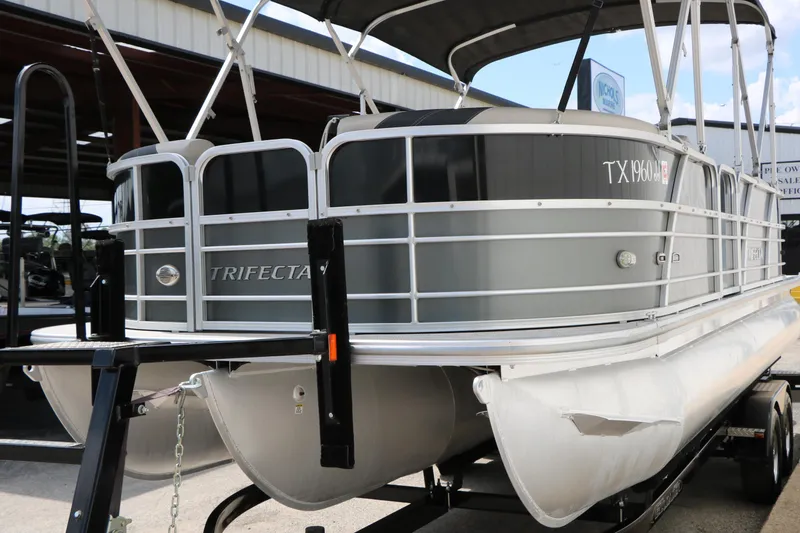 Slide: The Image of 2020 Trifecta 24RF LE pontoon boat on trailer, parked at marina. - 6