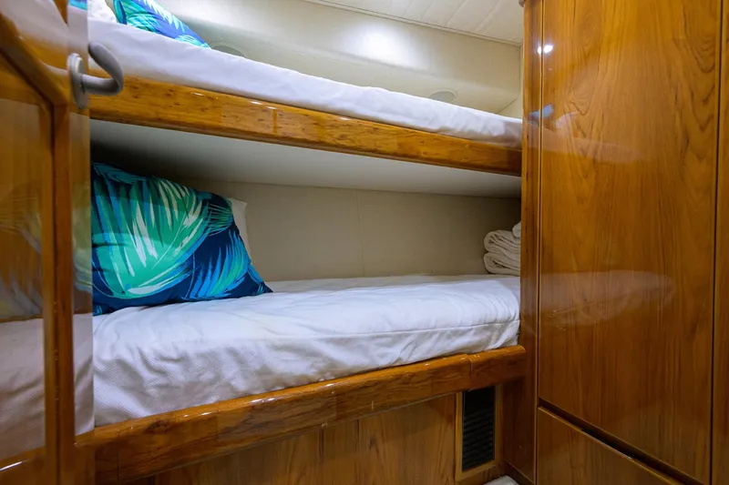 Slide: The Image of Bunk beds in 2015 Viking 62 Convertible yacht cabin with wooden finish and tropical pillows. - 29