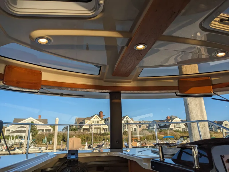 Slide: The Image of Interior view of a 2021 Ranger Tugs R-27 overlooking coastal houses. - 11