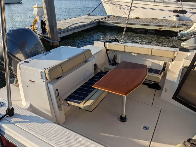 Slide: The Image of Ranger Tugs R-27 2021 with seating area and table at dock. - 14