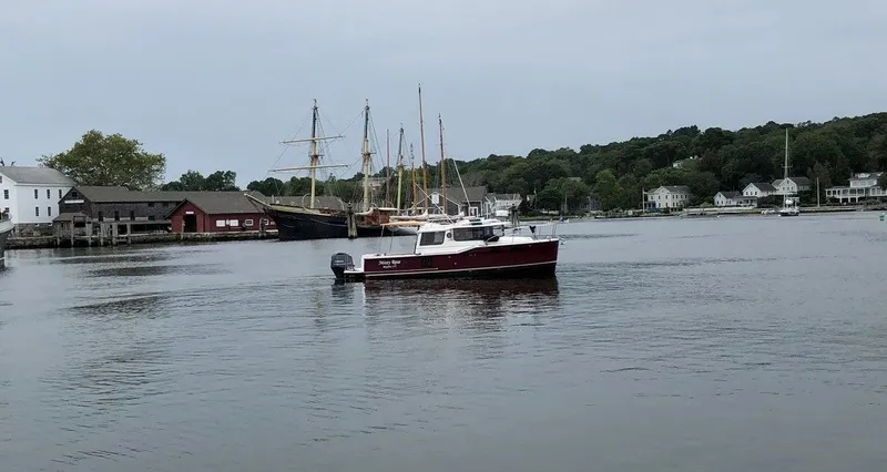 Slide: The Image of 2021 Ranger Tugs R-27 boat on calm water near historic harbor. - 4