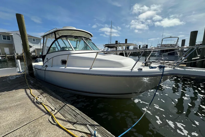 The Image of 2007 Pursuit OS 285 Offshore boat docked at marina under clear blue sky. - 0