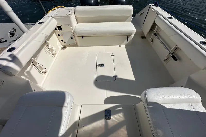 Slide: The Image of 2007 Pursuit OS 285 Offshore boat interior with white seating and storage compartments. - 11