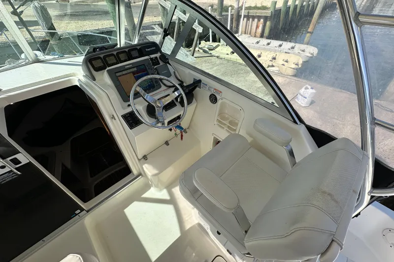 Slide: The Image of 2007 Pursuit OS 285 Offshore boat cockpit with steering wheel and navigation controls. - 16