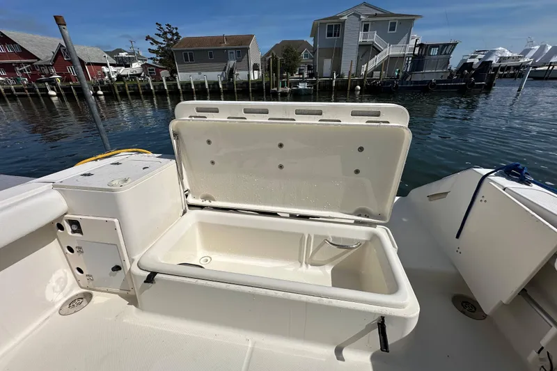 Slide: The Image of Open storage compartment on 2007 Pursuit OS 285 Offshore boat, docked near waterfront homes. - 17