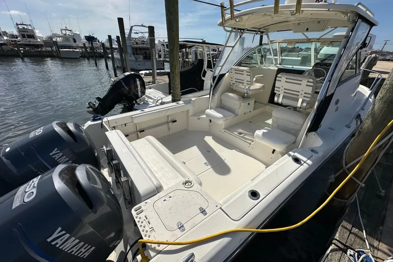 Slide: The Image of 2007 Pursuit OS 285 Offshore boat docked, featuring Yamaha engines and spacious seating area. - 2