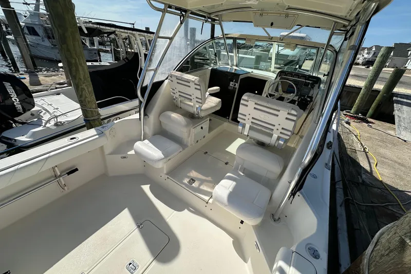 Slide: The Image of 2007 Pursuit OS 285 Offshore boat interior with helm and seating at dock. - 20